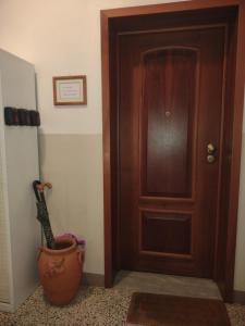 a room with a door and a guitar next to a vase at Arcobalenotoscano Convivio in Pescia +2 photos