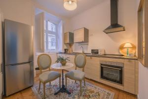 a kitchen with a table and chairs and a refrigerator at Sapateiros 44 in Lisbon