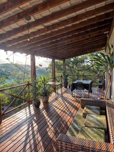 a wooden deck with a couch and a table on it at Casa Bouganville in Monte das Gameleiras