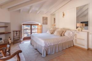 a bedroom with a large white bed in a room at Es Petit de Valldemossa in Valldemossa