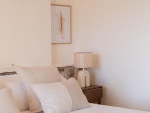a bedroom with a bed with pillows and a lamp at Es Petit de Valldemossa in Valldemossa
