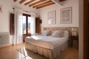 a bedroom with a large bed with white sheets at Es Petit de Valldemossa in Valldemossa