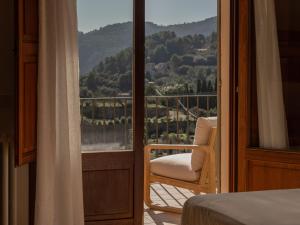 a bedroom with a bed and a chair on a balcony at Es Petit de Valldemossa in Valldemossa