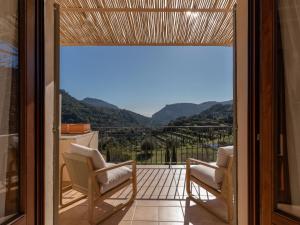 a balcony with two chairs and a view of the mountains at Es Petit de Valldemossa in Valldemossa