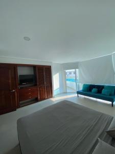 a living room with a blue couch and a tv at Laguito Apartment in Cartagena de Indias +23 photos