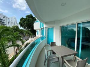 a balcony with a table and chairs and a swimming pool at Laguito Apartment in Cartagena de Indias
