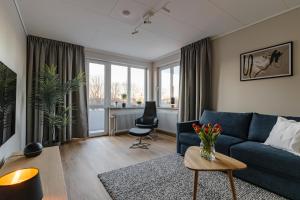a living room with a blue couch and a table at Förstklassig bekvämlighet! in Jönköping
