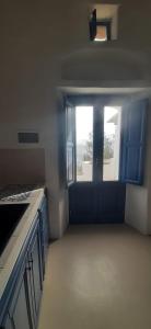 a kitchen with blue cabinets and a large window at L'Olivuzza in Alicudi