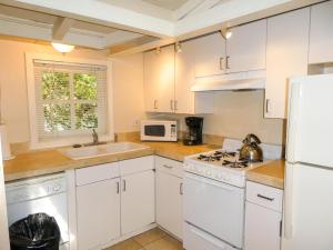 a kitchen with white appliances and a white refrigerator at Carmel Dolores Cottages in Carmel