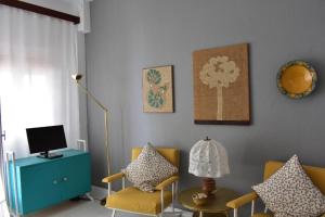 a living room with two chairs and a television at Cozy Seaview Apartment in Siviri
