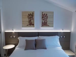 a bedroom with a bed with two pictures on the wall at Villa Grazia 49 in Solicchiata