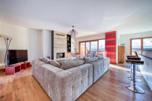 ein Wohnzimmer mit einem großen Sofa und einem TV in der Unterkunft Lodge 8 next to ski lift and sportcenter in Champéry