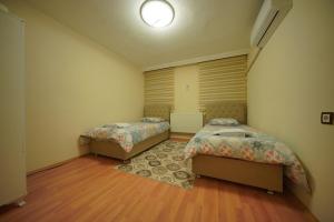 a bedroom with two beds and a rug at Cappadocia Silkroad House 2 in Avcılar