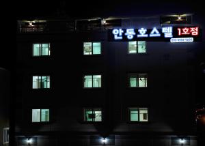 wysoki budynek z znakiem przed nim w obiekcie The 1st Andong Hostel w mieście Andong