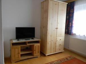 a living room with a television and a wooden cabinet at Ferienwohnung Gasser in Wenns