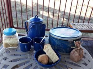 a table with a blue pot and some bread on it at Dopper Joris Bruidswa Adam se Uitspanning in Orania