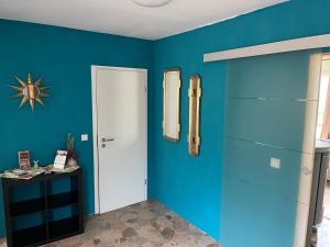 Habitación con paredes azules y puerta blanca en Geisingblick, en Geising 4 fotos más