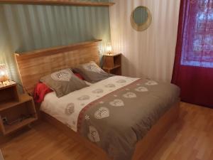 a bedroom with a bed with a wooden head board at Gites Du Ladhof in Colmar