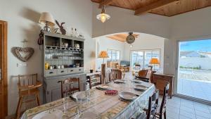 una cucina e una sala da pranzo con tavolo e sedie di Belle maison familiale avec piscine et parking a Loix