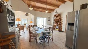 una cucina e una sala da pranzo con tavolo e sedie di Belle maison familiale avec piscine et parking a Loix Altre 6 foto