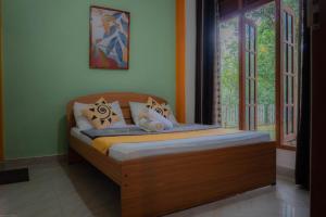 a bedroom with a wooden bed with a window at Lily Villa Ella in Ella