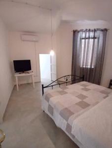 una camera da letto con un letto e una TV a schermo piatto di Casa Vacanze Caterina a Matino
