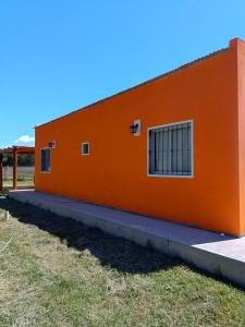 ein orangefarbenes Gebäude mit zwei Fenstern an der Seite in der Unterkunft Campos del Paraná Casa Quinta in San Pedro + 20 Fotos