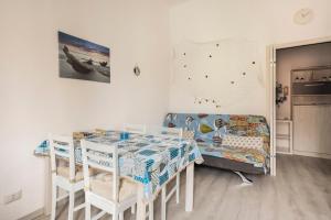 a room with a table and a bed and a couch at Leo Holiday Homes in Deiva Marina