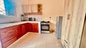 a kitchen with wooden cabinets and a refrigerator at Cozy & Spacious 2 Bed Apt in Malindi in Malindi
