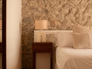 a bedroom with a bed and a lamp on a table at Es Petit de Valldemossa in Valldemossa