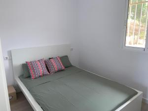 a bed in a room with two pillows on it at CALARREONA - Apartamento a 100 metros de la playa in Águilas