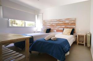 Un dormitorio con dos camas y una pared de madera. en casa gerona villa allende, en Villa Allende 50 fotos más