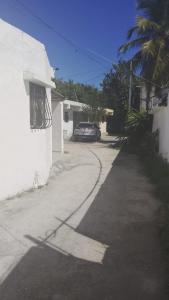 a street with a car parked next to a house at Guest House A&H - Boca Chica Beach & Airport in Boca Chica