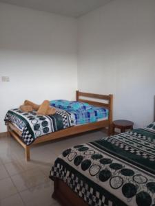two beds sitting next to each other in a room at Casa Niño Peregrino Salinas in Salinas
