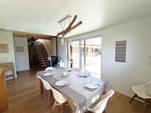 een eetkamer met een witte tafel met witte stoelen bij Le Carrelet 300m walk to a beach in Fouras