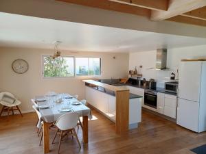 een keuken met een tafel en een keuken met een tafel en stoelen bij Le Carrelet 300m walk to a beach in Fouras