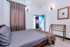a bedroom with a bed and a mirror at Madiha Ceylon Hotel in Matara
