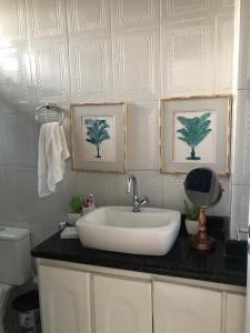 a bathroom with a sink and two pictures on the wall at Apartment in Ondina, Carnival Circuit, Luxury in Salvador