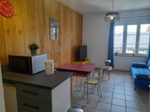 a kitchen and a living room with a couch and a table at gite de l'auberge in Olby