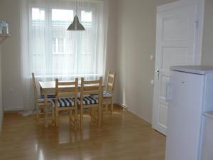 ein Esszimmer mit einem Tisch, Stühlen und einem Fenster in der Unterkunft Apartmán U krále Tylova 516 in Jičín