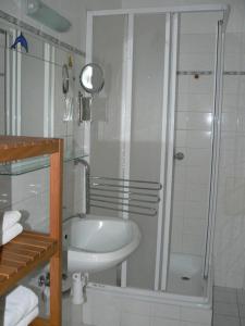 ein Bad mit einer Dusche und einem weißen Waschbecken in der Unterkunft Apartmán U krále Tylova 516 in Jičín
