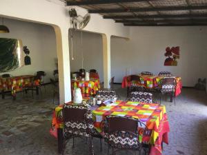 a group of tables and chairs in a room at Campement Courbine in Ndangane