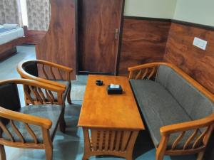 a table and two chairs and a couch with a table at Dkgardenia24 in Kanakapura