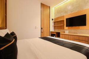 a bedroom with a bed and a flat screen tv at Keenan Living Perumnas in Yogyakarta +25 photos