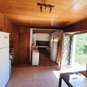 a kitchen with white appliances and a wooden ceiling at Cabañas las Garzas in Guazuvira