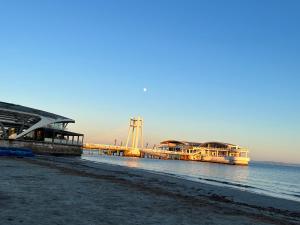 a bridge over the water next to a beach at Colombia Apartments&Rooms in Durrës