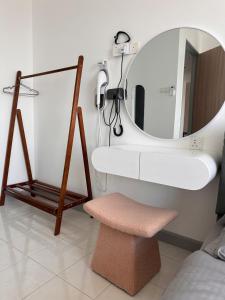 a bathroom with a sink and a mirror and a stool at SURIA HomeStay Kuala Terengganu City Center, 8 pax, 150M to KTCC Mall in Kuala Terengganu