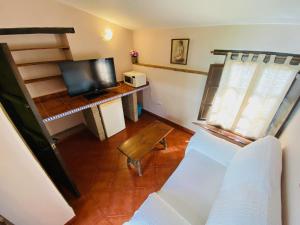 a living room with a couch and a television at Posada La Casa Grande in Jimena de la Frontera