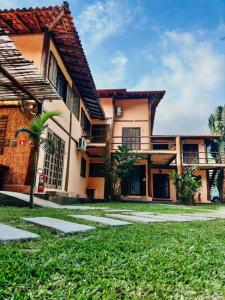 budynek z palmą przed nim w obiekcie Pousada AimeMaresias - Loft - Seu Paraíso - 8min da Praia w mieście São Sebastião