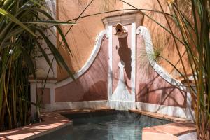 a swimming pool with a water fountain next to a building at Villa Domingues in Lisbon